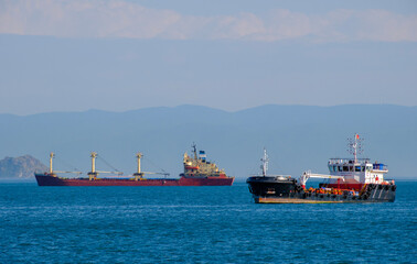 Fototapeta premium Black coastal tanker and red bulk carrier sharing the busy marine shipping lane