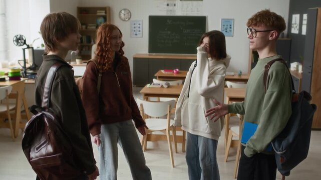 Four smiling students with backpacks chatting animatedly in bright, modern classroom equipped with 3D printers