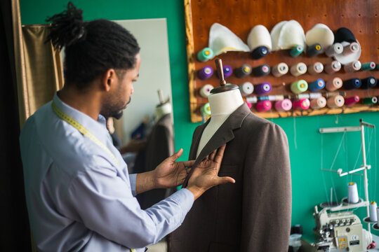 Photo showing african american tailor fitting suit on mannequin -stock photo