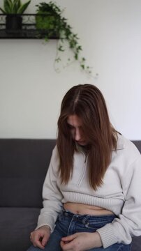Vertical screen Young woman looks at stomach and worries about body changes before starting weight loss injections and modern obesity treatment