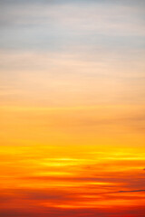 Fototapeta premium Sky sunset,Beautiful sunrise sky with vibrant gradient orange and gold colors and soft blue, Clear atmosphere with wispy clouds. Peaceful, perfect for background and copy space, vertical