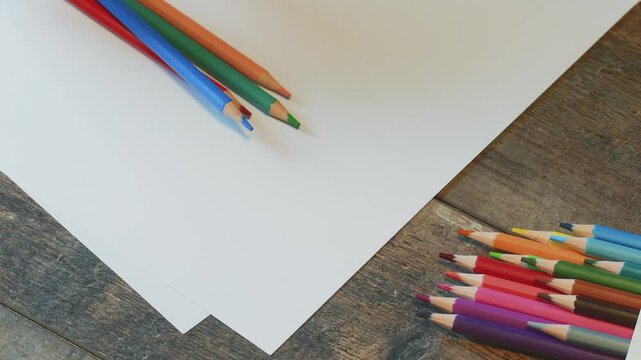 Creating art with colored pencils on drawing paper at a wooden table