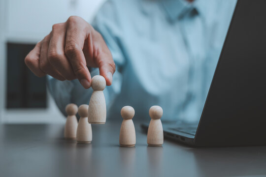 Talent selection human resources recruitment concept businessman hand picking wooden peg doll choosing best candidate for promotion team building standing out leadership