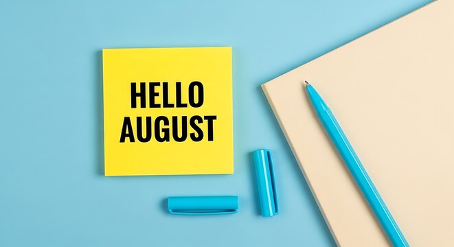 Hello August message on yellow sticky note, summer monthly calendar concept, blue office desk background with pen and notebook