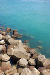 Obraz premium Clear turquoise sea water with concrete breakwater blocks