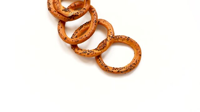Crispy baked bagels with poppy seeds floating composition