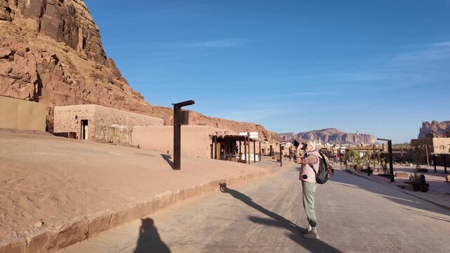 AlUla Old Town featuring traditional buildings and structures with ancient AlUla Fort,overlooking unique desert mountains and historical topography of Saudi Arabia under clear blue sky in Saudi Arabia
