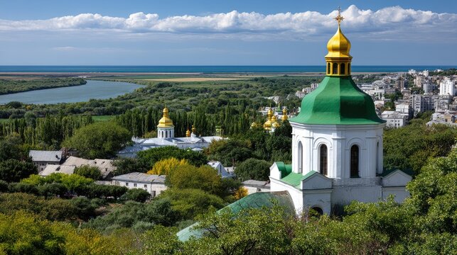 Green and yellow domed church stands in open countryside near river with trees under blue sky and clouds