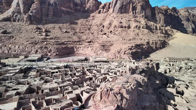 Ancient desert settlement of AlUla Old Town, Saudi Arabia, seen from above with layers of mudbrick architecture, rocky canyon scenery, and AlUla Fort standing watch over the landscape.