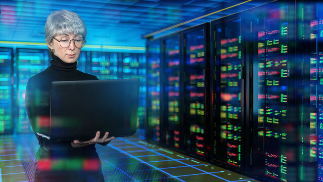 Data center, IT infrastructure. Female technician uses laptop while monitoring server racks and network equipment in secure cloud facility