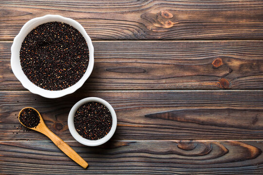 quinoa seeds in bowl and spoon on colored background. Healthy kinwa in small bowl. Healthy superfood