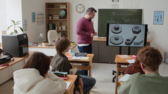 High angle shot of male teacher giving lecture on 3D modeling, using presentation on screen to group of students in modern classroom