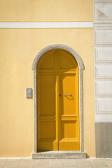 Fototapeta premium Minimal yellow mediterranean door on pastel facade