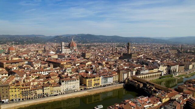 Florence aerial drone view in Italy with Ponte Vecchio Duomo and buildings reflection. Cinematic historic town center cityscape with Galleria degli Uffizi river Arno at summer. Iconic landmarks Europe