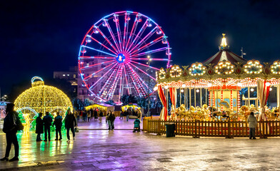 Valletta, Malta, festive attractions with carousel and colorful ferris wheel in an atmospheric evening scene © EKH-Pictures