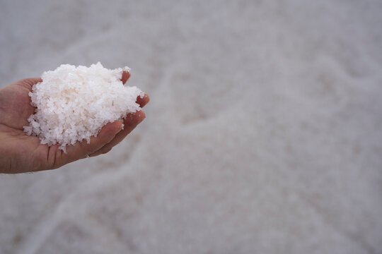 Handful of sicilian italian marine salt in the extraction pans