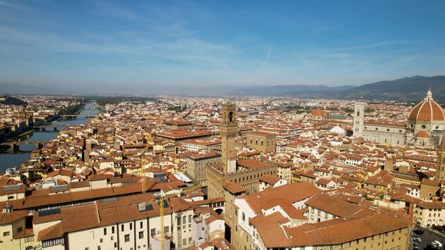 aerial view in Florence Italy with iconic Duomo, Uffizi gallery and Ponte Vecchio. Cinematic historic town center cityscape with river Arno at summer . Iconic Tuscan travel panorama.