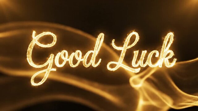 A glowing golden script that reads "Good Luck" is set against a backdrop of swirling, ethereal golden smoke or fabric.