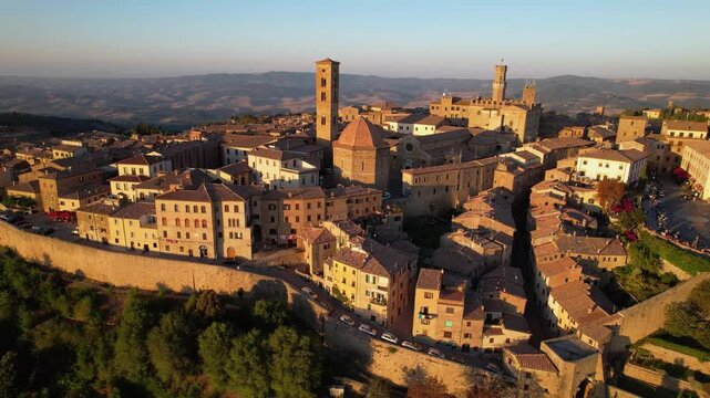 Italy Volterra Tuscany aerial 4K drone sunset view medieval hilltop town, rolling hills countryside tuscan landscape historic borgo. cinematic overflight tourism destination