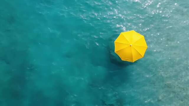 Yellow umbrella on turquoise water background