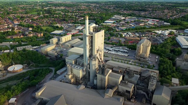 Aerial drone view of industrial kiln towers and chimney stacks at a large scale concrete production facility in Rugby UK
