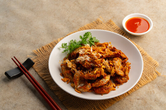 Deep Fried Pork Intestines with Crispy Garlic in white plate.with chilli sauce.