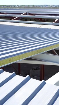 A detailed mid-range shot of a sandwich panel installed on the roof of a warehouse hangar