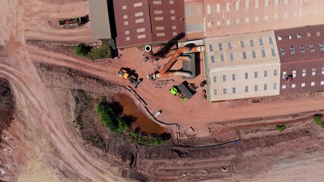 Aerial view of heavy plant machinery, earthmoving equipment, and industrial chimney stacks at a brick manufacturing facility in Tamworth, Staffordshire, UK.