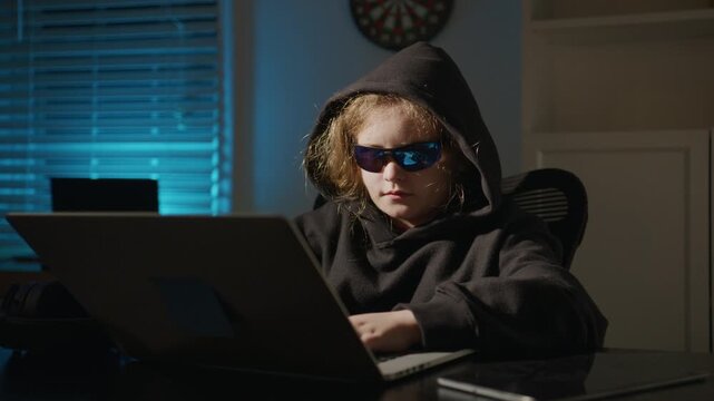 Kid hacker coding late at night. Kid hacker studying cyberattack risks. Kid hacker learning information security. Kid hacker focused on technology skills.