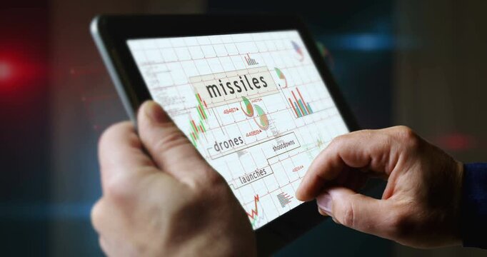 Missiles drones charts and graphs diagram on touchscreen pad display. Finger touch tablet screen in hand. Digital analysis and report.