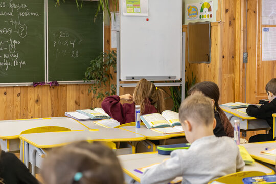 Elementary school children sitting at desks in a classroom, studying academic subjects with focus during a lesson to foster intelligence and develop essential learning skills