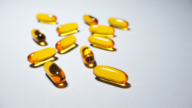 Close up of some yellow capsules containing vitamin e with a capacity of 300 iu per capsule.