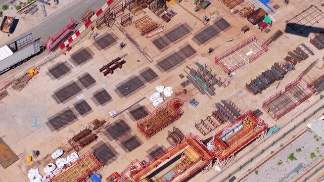 Aerial view of heavy steel rebar mesh and industrial reinforcing bars stacked at a massive civil engineering infrastructure construction site.