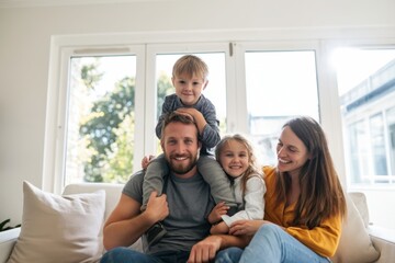 Obraz premium The family sitting on a sofa sharing joyful moments together in a bright living room