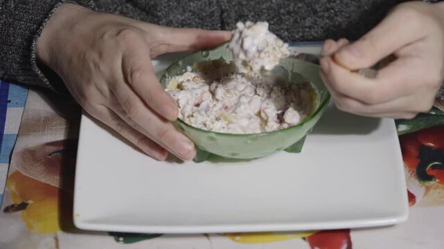 Adding superfood chia seeds to strawberry yogurt with oatmeal and cornflakes