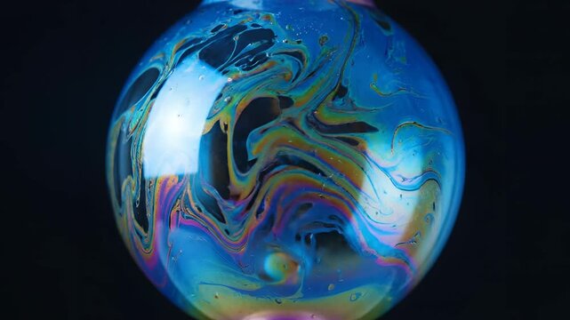 Closeup Macro Shot of a Colorful Soap Bubble Reflecting Light.