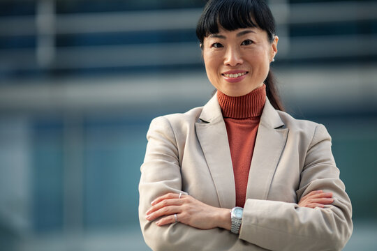 Confident businesswoman smiling outside modern office