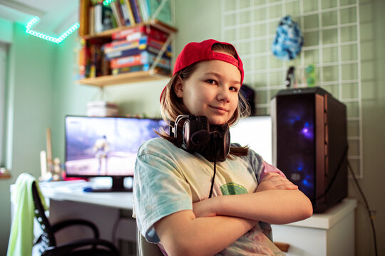 Confident preteen gamer with headphones in bedroom gaming setup