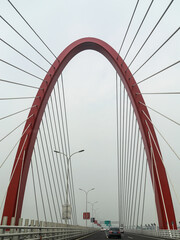Fototapeta premium Red Cable-Stayed Bridge with Symmetrical Arch Design