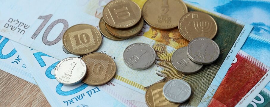 Israeli shekel money bills and coins on table. Israel cash of ILS currency close up