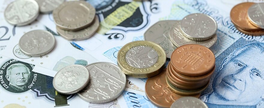 British pound money bills and coins on table. United Kingdom cash of GBP currency close up