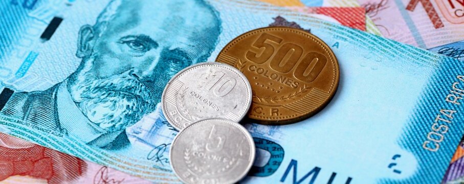 Costa Rican colon money bills and coins on table. Costa Rica cash of CRC currency close up