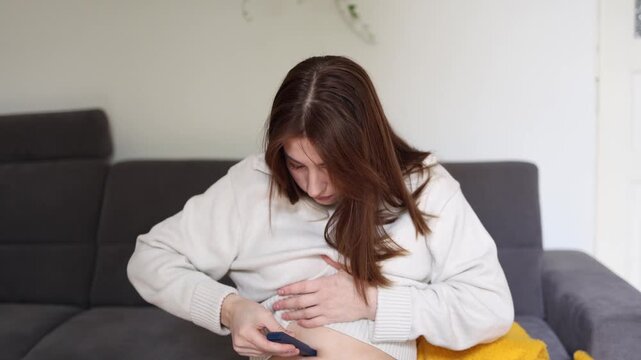 Young woman injects insulin into her stomach at home managing diabetes independently and maintaining healthy daily routine while monitoring chronic condition