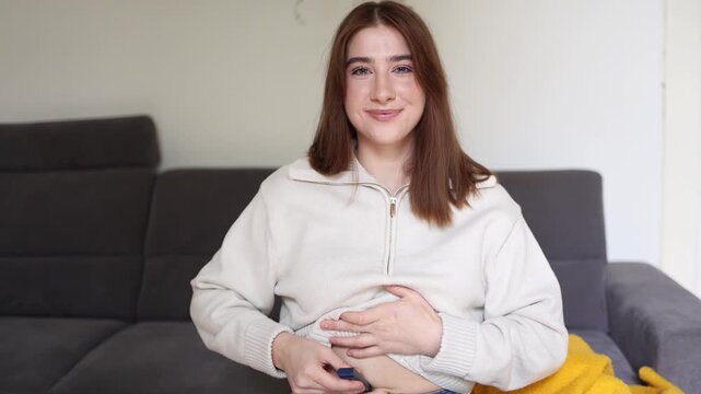 Young woman with diabetes injects insulin into her stomach at home smiling confidently and showing that chronic illness does not stop active happy modern life