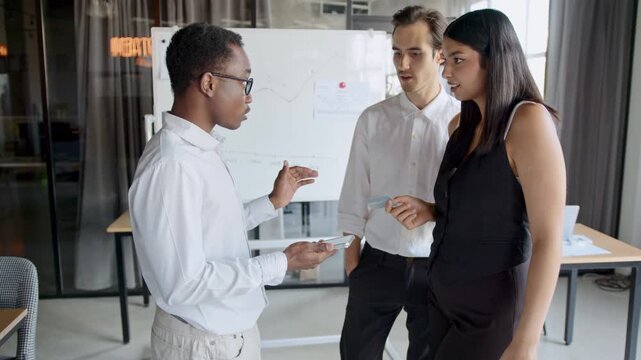 Young couple consults with a financial sales agent about credit card services and purchase plans at a modern office. They engage in a serious discussion about banking and buying options.