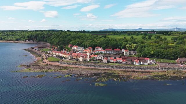 Aerial panorama of the historic West Wemyss village in Fife. A scenic view of the traditional Scottish coastline with colorful houses along the blue water of the Firth of Forth