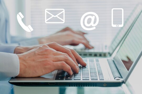 Business Man working on computer with contact ikons
