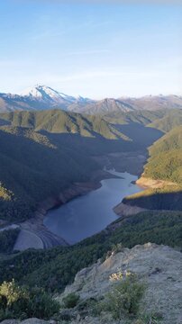 Parral, Maule Region - May 9, 2026: Mirador de los Riscos de Bullileo, from where you can see the Bullileo reservoir with little water reserve, and the Nevado de Longavi volcano, at sunset.