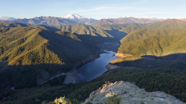 Parral, Maule Region - May 9, 2026: Mirador de los Riscos de Bullileo, from where you can see the Bullileo reservoir with little water reserve, and the Nevado de Longavi volcano, at sunset.