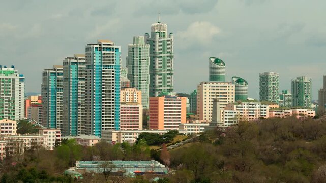 Panoramic view of Pyongyang from Yanggakdo Hotel. Taedong River in morning fog. Ryugyong Hotel and modern residential complex upstream. Atmospheric, calm, iconic. Pyongyang, North Korea